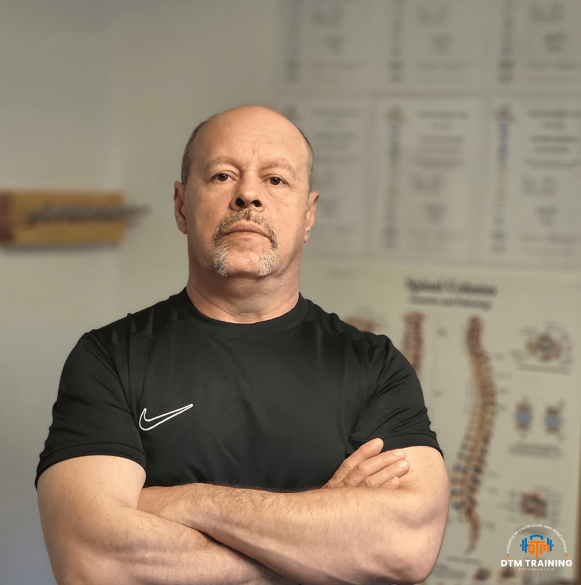 Daniel Batir, Personal Trainer and Sports Massage Therapist at DTM Training in London, standing with arms crossed in a training studio.