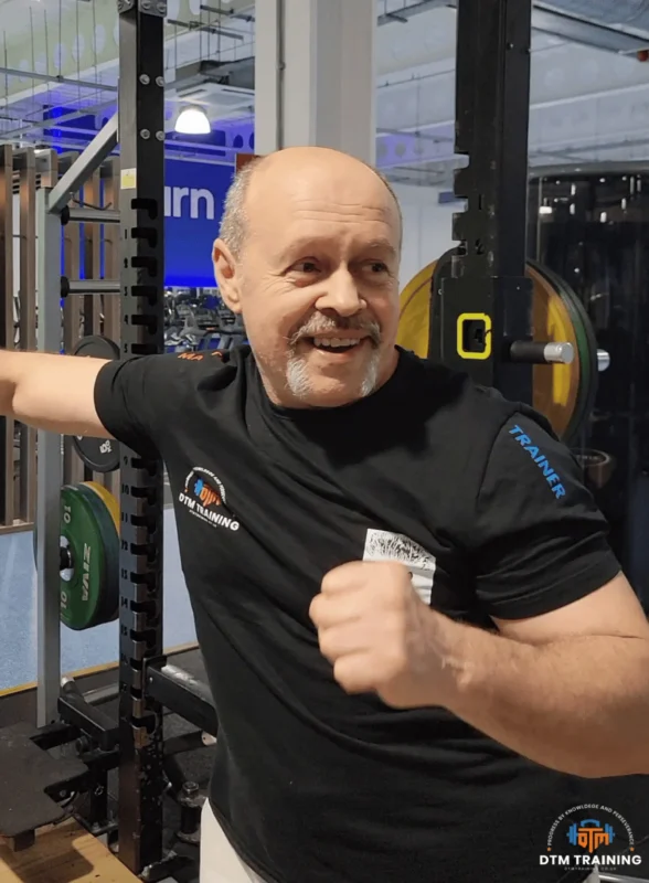 Daniel Batir smiling during a training session in a gym, demonstrating an approachable and supportive personal training style.