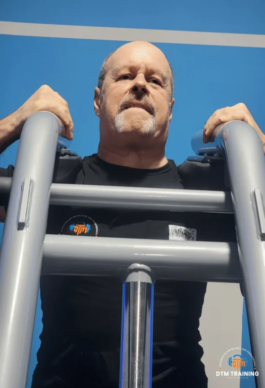 Daniel Batir performing a machine-based strength exercise in a commercial gym, demonstrating controlled resistance training and proper exercise technique.