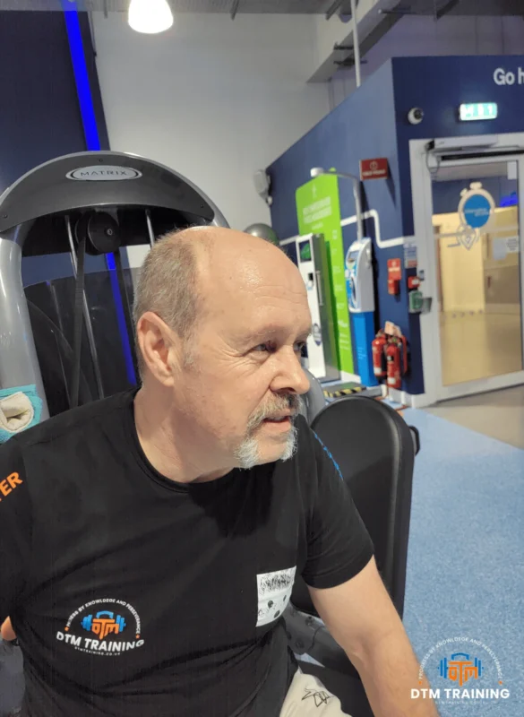 Daniel Batir, London personal trainer and strength coach, seated in a gym environment during a coaching and training session.