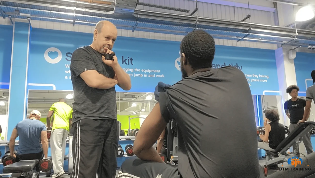 Daniel Batir coaching a personal training client during a gym consultation and workout session at DTM TRAINING in London.